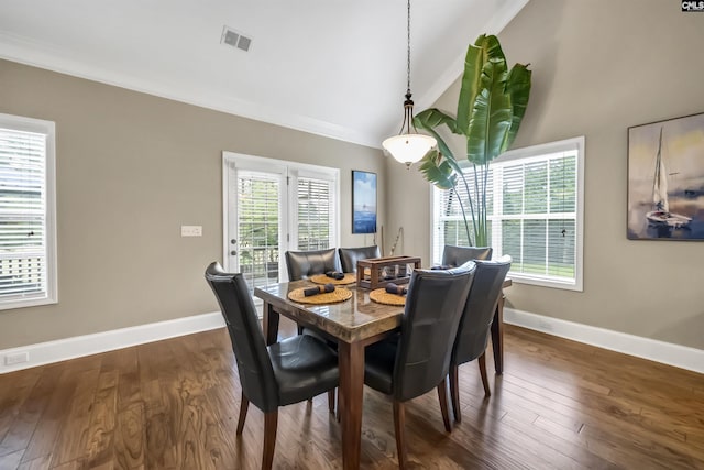 dining room featuring dark wood-type flooring, plenty of natural light, and lofted ceiling