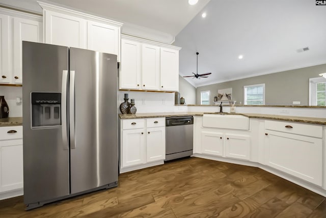 kitchen featuring white cabinets, stainless steel appliances, and lofted ceiling