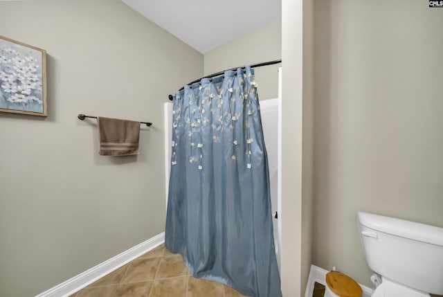 bathroom featuring toilet, a shower with shower curtain, and tile patterned flooring