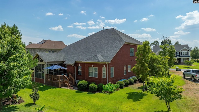 back of house with a deck and a yard