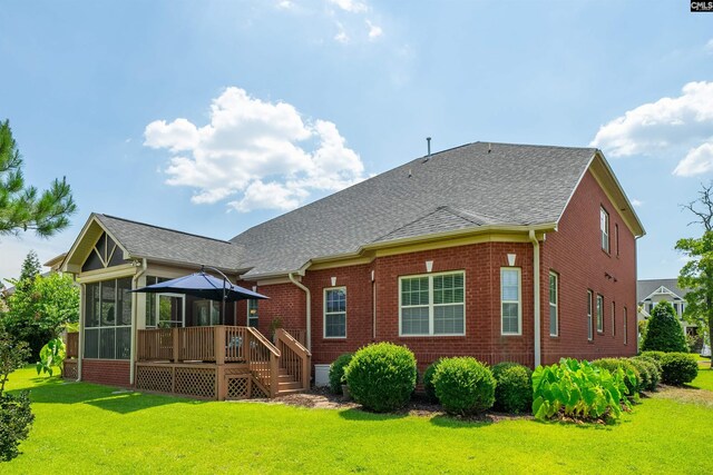 back of property featuring a wooden deck, a gazebo, a yard, and a sunroom