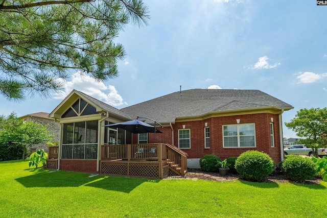 rear view of property with a deck, a sunroom, and a yard