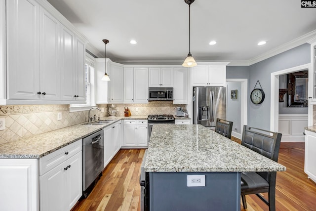 kitchen with sink, hanging light fixtures, a center island, and stainless steel appliances