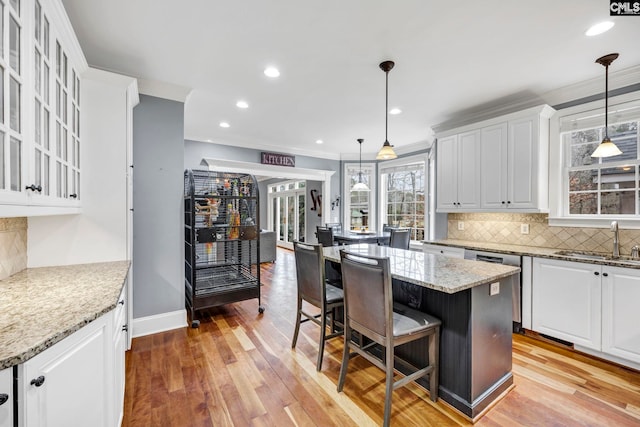 kitchen with hanging light fixtures, white cabinets, and a kitchen island