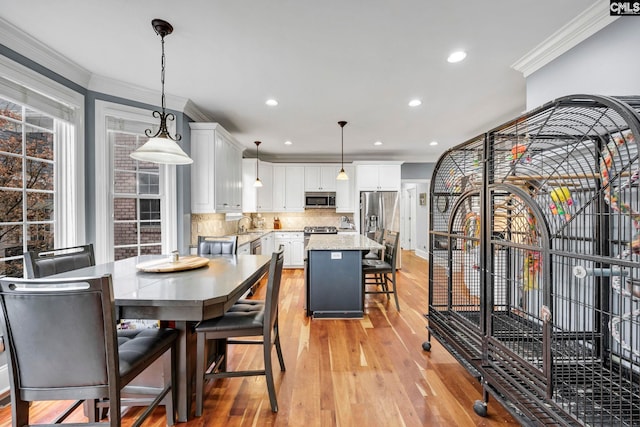 dining room featuring light hardwood / wood-style flooring and ornamental molding