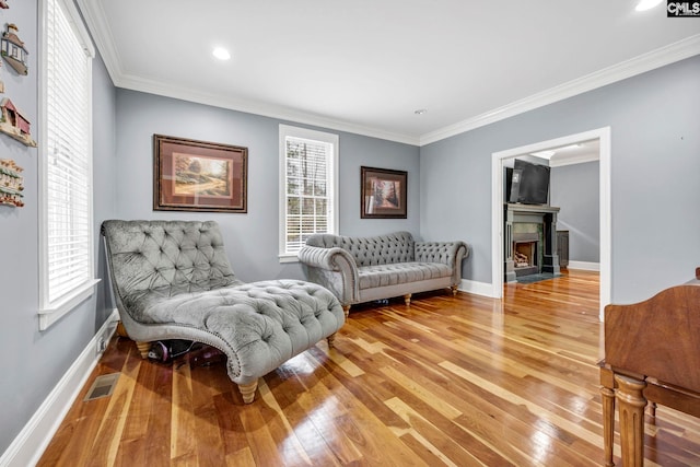 sitting room with crown molding and wood-type flooring