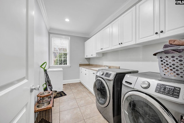 laundry room featuring washing machine and dryer, cabinets, sink, light tile patterned flooring, and crown molding