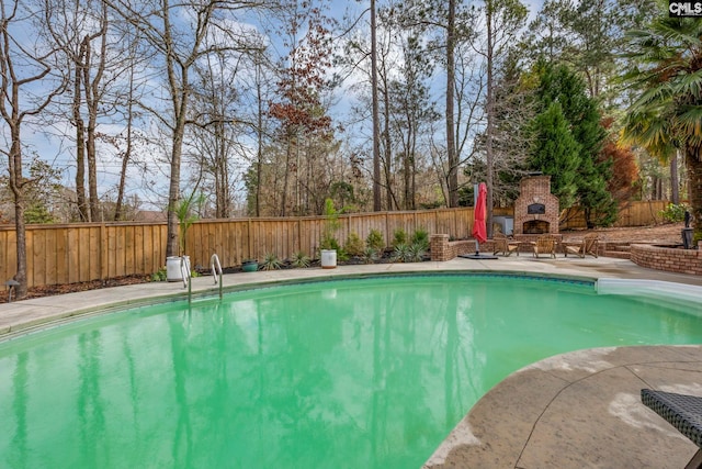 view of pool featuring an outdoor fireplace and a patio