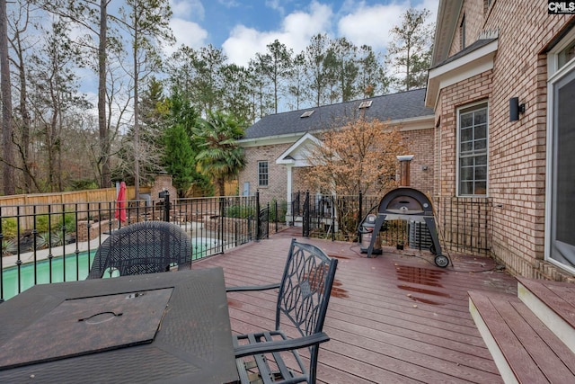 deck featuring a fenced in pool