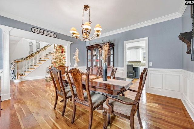 dining space with an inviting chandelier, crown molding, and light hardwood / wood-style floors