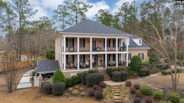 greek revival inspired property featuring a porch and a balcony