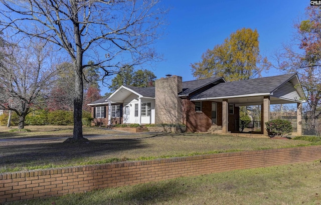 ranch-style house featuring a front lawn and a carport