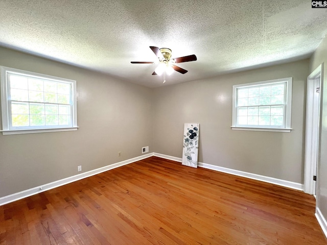 unfurnished room with ceiling fan, hardwood / wood-style floors, and a textured ceiling