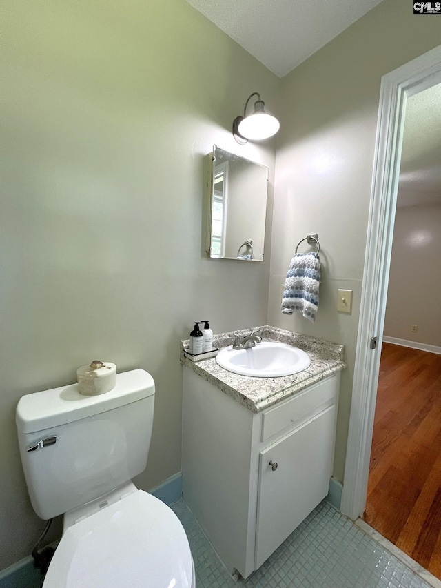 bathroom with toilet, tile patterned floors, and vanity