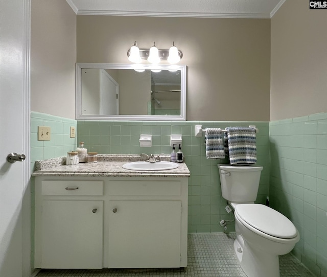 bathroom featuring toilet, tile patterned flooring, tile walls, crown molding, and vanity