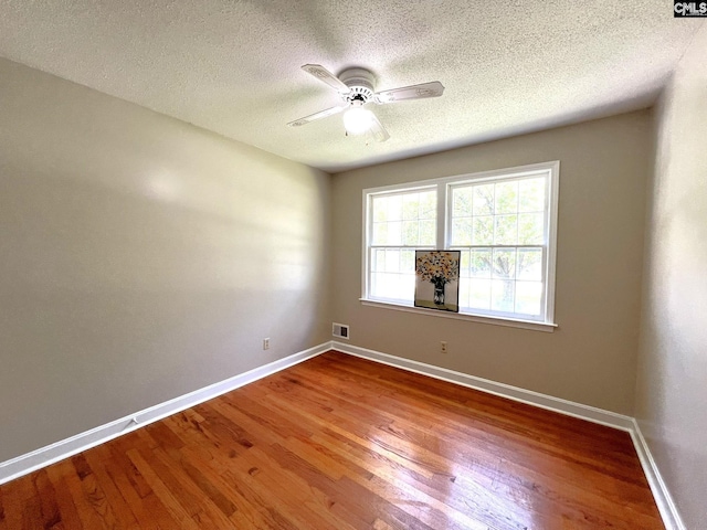 spare room with ceiling fan, hardwood / wood-style floors, and a textured ceiling