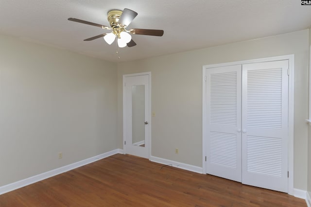 unfurnished bedroom with ceiling fan, dark hardwood / wood-style flooring, and a closet