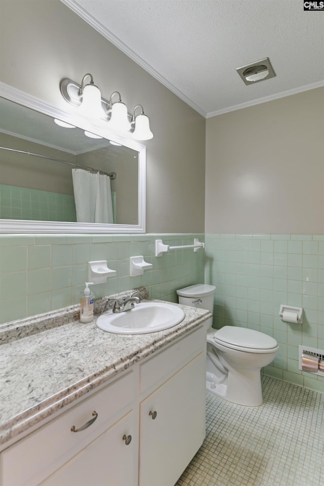 bathroom with toilet, tile walls, tile patterned floors, crown molding, and vanity