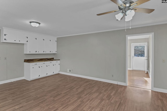 interior space with hardwood / wood-style flooring, crown molding, and ceiling fan