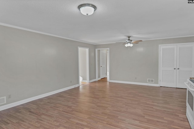 unfurnished living room featuring ceiling fan, ornamental molding, and light wood-type flooring