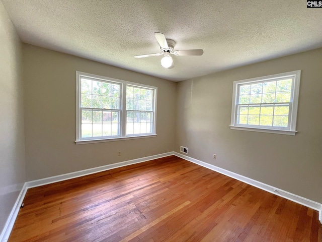 empty room with ceiling fan, a textured ceiling, and hardwood / wood-style floors