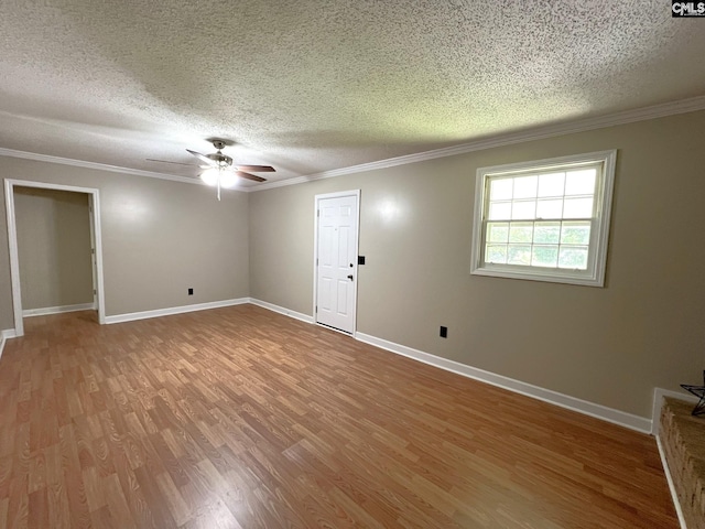 unfurnished room featuring a textured ceiling, ornamental molding, and hardwood / wood-style floors