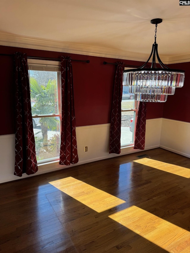 unfurnished dining area featuring dark hardwood / wood-style floors and ornamental molding