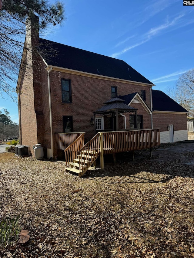 back of property with a deck, cooling unit, and a gazebo