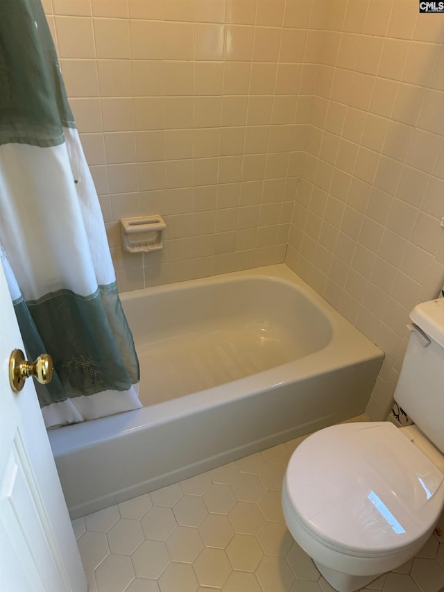 bathroom featuring toilet, tile patterned floors, and shower / bathtub combination with curtain