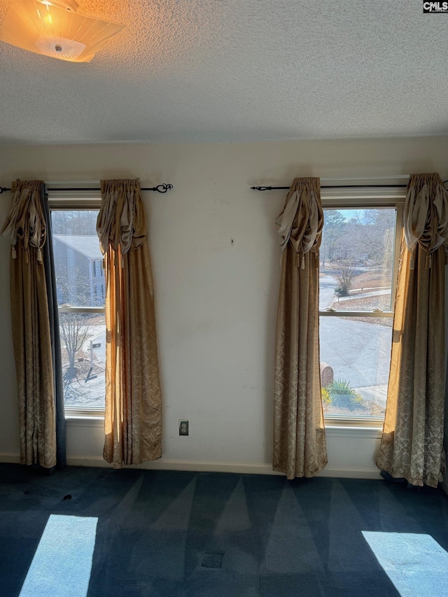 carpeted spare room with a textured ceiling