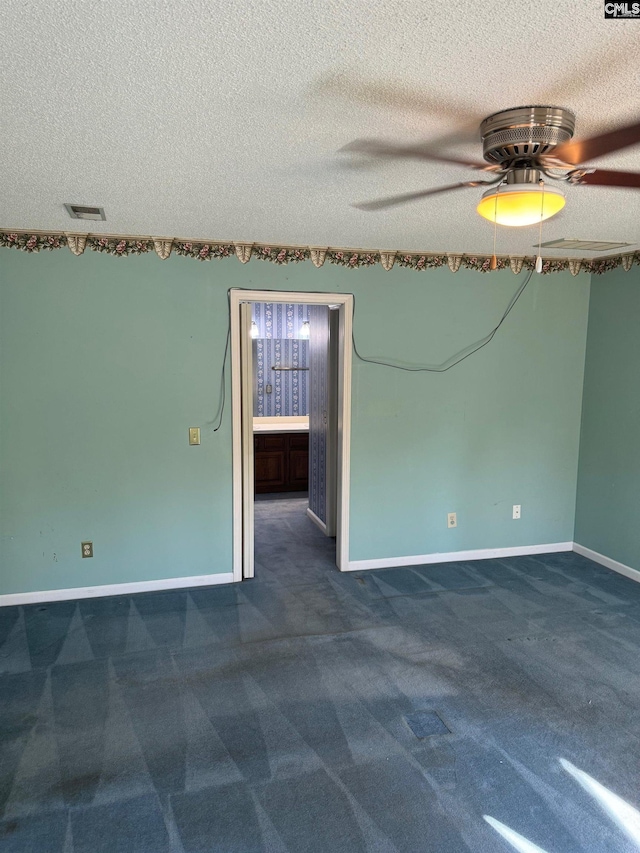 unfurnished room featuring ceiling fan, dark carpet, and a textured ceiling