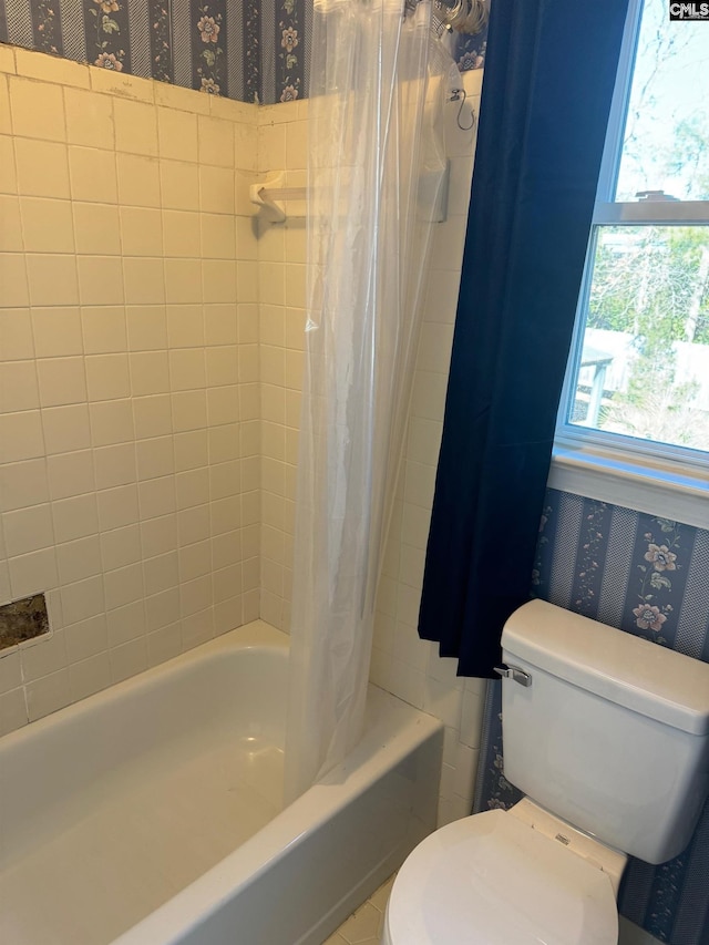 bathroom featuring toilet and shower / bathtub combination with curtain