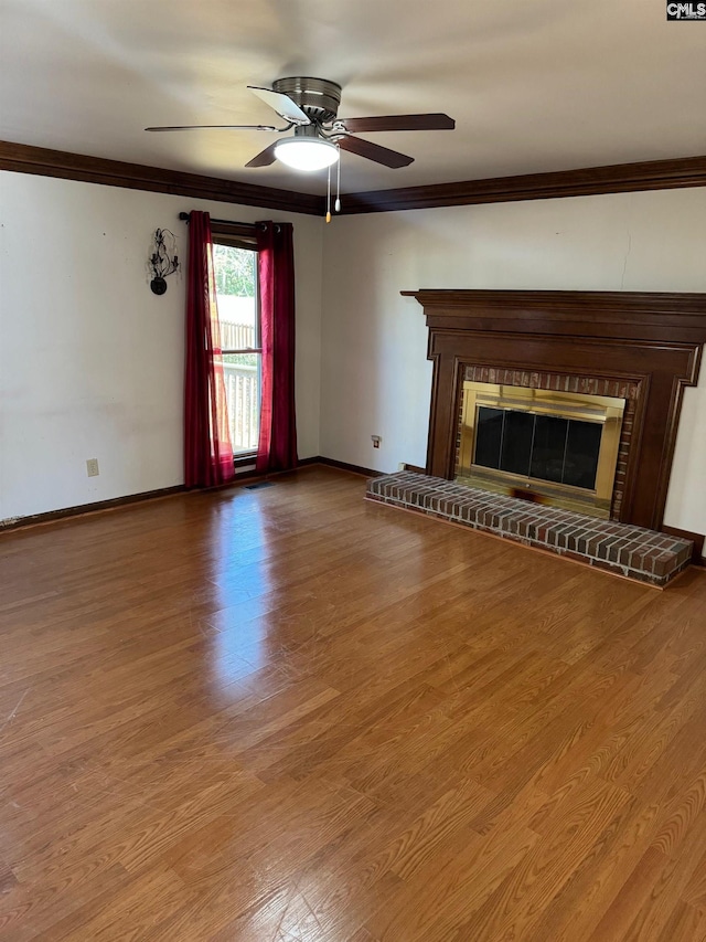 unfurnished living room with ceiling fan, ornamental molding, a fireplace, and hardwood / wood-style flooring