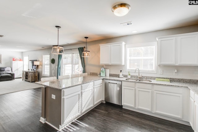 kitchen featuring white cabinetry, decorative light fixtures, stainless steel dishwasher, light stone counters, and sink