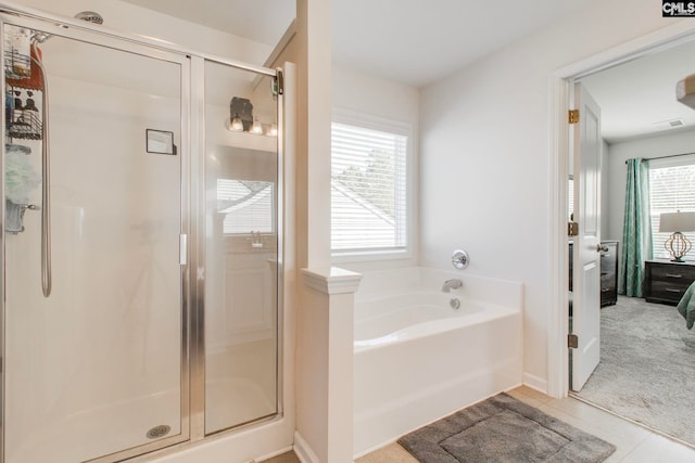 bathroom with plenty of natural light, tile patterned floors, and shower with separate bathtub