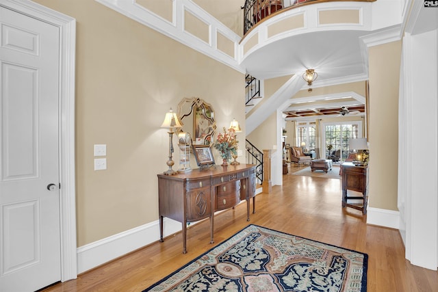 foyer featuring hardwood / wood-style flooring, ornamental molding, and ceiling fan