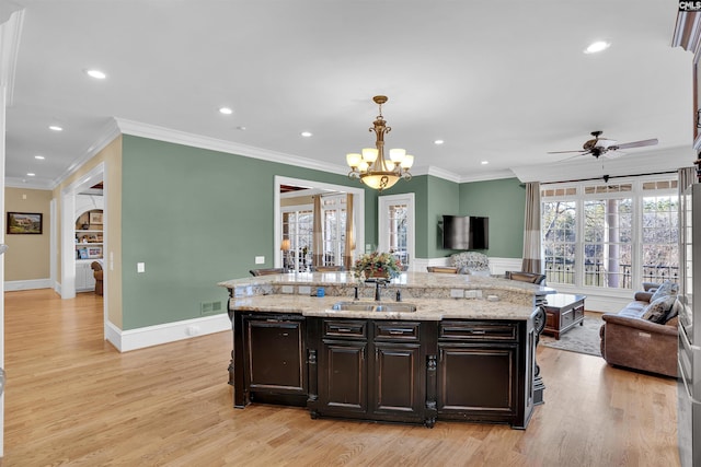 kitchen with decorative light fixtures, light wood-type flooring, dark brown cabinets, and ornamental molding