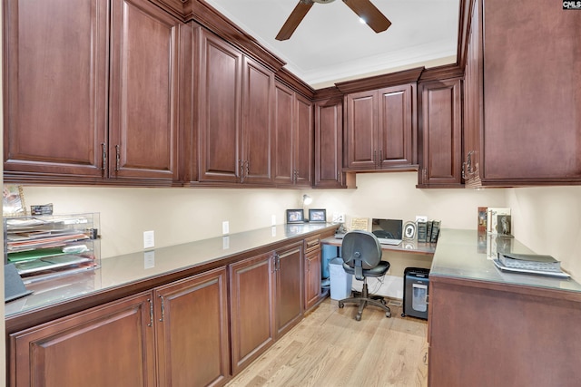 office area featuring ceiling fan, ornamental molding, built in desk, and light hardwood / wood-style floors