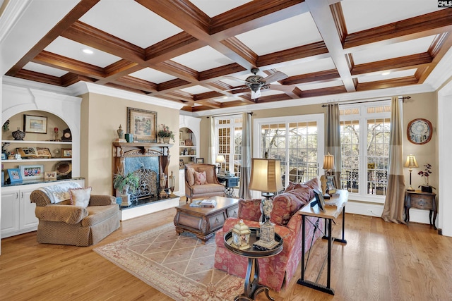 living room with built in shelves, ceiling fan, light hardwood / wood-style flooring, beam ceiling, and coffered ceiling