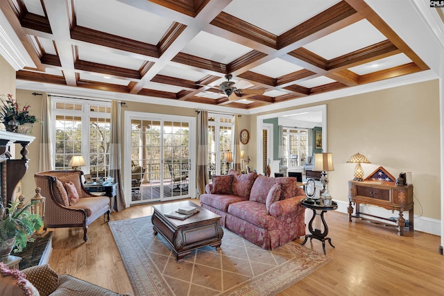 living room featuring ceiling fan, beam ceiling, coffered ceiling, light wood-type flooring, and ornamental molding