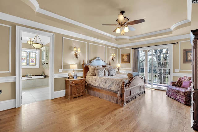 bedroom with ceiling fan, access to exterior, a tray ceiling, and multiple windows