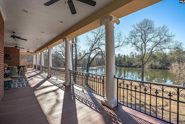 deck with a water view and ceiling fan