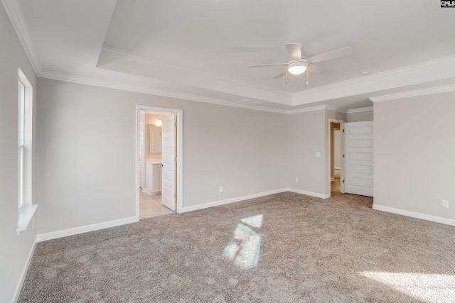 unfurnished room with carpet floors, baseboards, a tray ceiling, and a ceiling fan