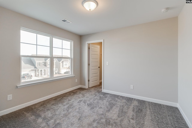 carpeted spare room with visible vents and baseboards