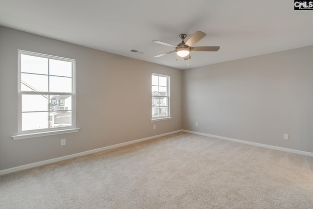 unfurnished room featuring light carpet, baseboards, visible vents, and a ceiling fan