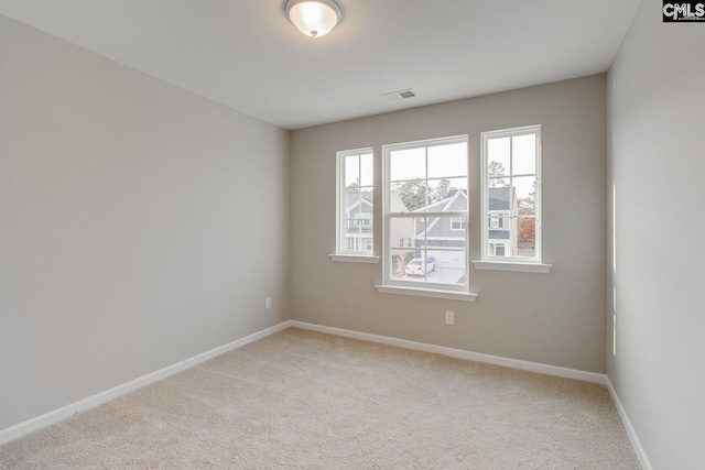 empty room with light carpet, baseboards, and visible vents