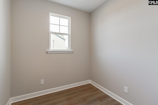 spare room featuring baseboards and wood finished floors