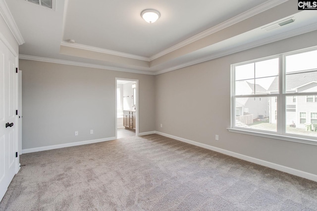 unfurnished room featuring baseboards, visible vents, a raised ceiling, ornamental molding, and carpet floors