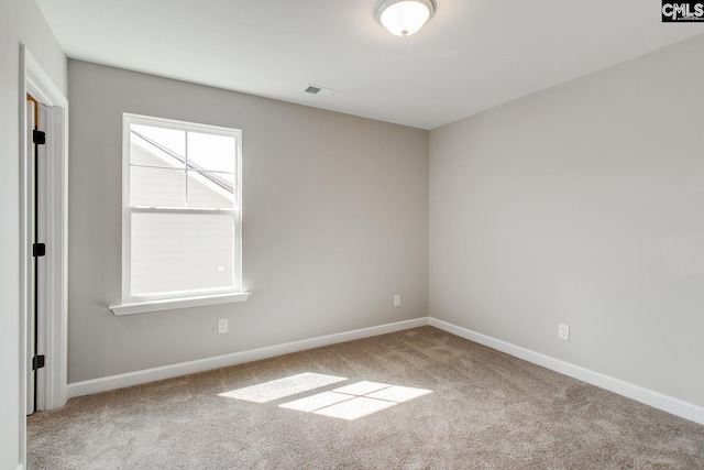 carpeted spare room featuring visible vents and baseboards