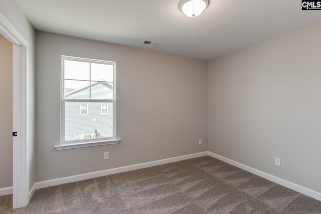 unfurnished room featuring baseboards, visible vents, and carpet flooring